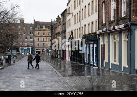 Edinburgh, Scotland, UK. 26 December 2020. Scenes from Edinburgh City Centre on a wet and windy Boxing Day during storm Bella. Today is first day that Scotland is under level 4 lockdown and all non essential shops and businesses are closed. As a result the streets are almost deserted with very few people venturing outside. Pic; Bars and restaurants all closed on The Grassmarket in the Old town.   Iain Masterton/Alamy Live News Stock Photo