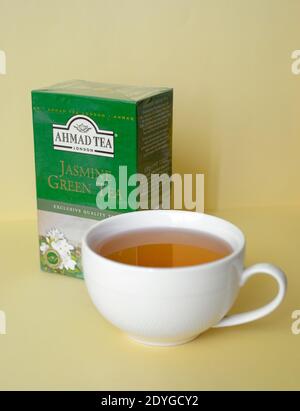 Ahmad tea. Jasmine green tea. A white cup filled with tea on a yellow background Stock Photo