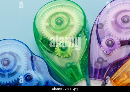 Stationery correction tapes are Multicolored on a blue background. Close-up. Blue, green, yellow, lilac Stock Photo