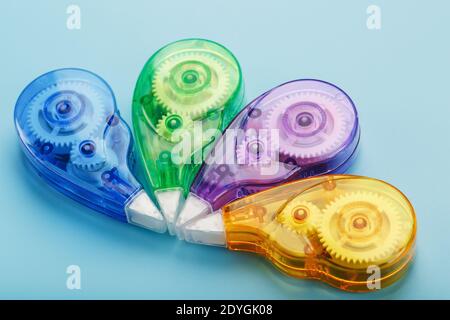 Stationery correction tapes are Multicolored on a blue background. Free space. The view from the top. Blue, green, yellow, lilac Stock Photo