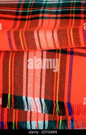 Vertical photo of textile with a printed pattern. Red checkered plaid fabric. Royal fashion with traditional Scottish pattern. Close up tartan plaid Stock Photo