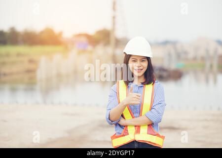 Female engineer with helmet showing thumb up as ok sign at construction site. Power of women, Gender equality, Working women, Confident Female Enginee Stock Photo