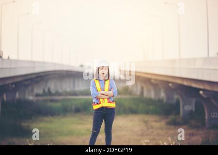 Female engineer with helmet showing thumb up as ok sign at construction site. Power of women, Gender equality, Working women, Confident Female Enginee Stock Photo