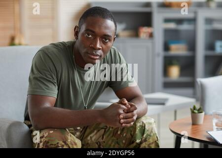 Portrait of African military man looking at camera while sitting on sofa at home Stock Photo