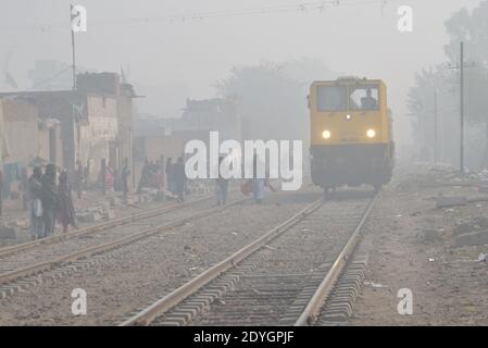 Pakistani Commuters make their way amid dense fog on a cold winter  in Lahore Stock Photo