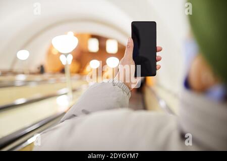 Close-up of woman holding mobile phone while making photo of underground Stock Photo