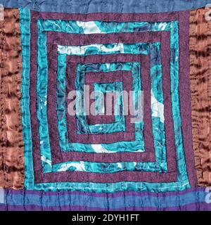 textile background - stitched detail of patchwork fabric with spiral pattern Stock Photo