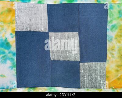 textile background - stitched fragment of patchwork cloth from blue and silver fabrics Stock Photo
