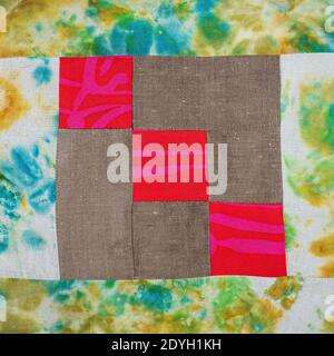 textile background - stitched detail of patchwork cloth from red and brown fabrics Stock Photo