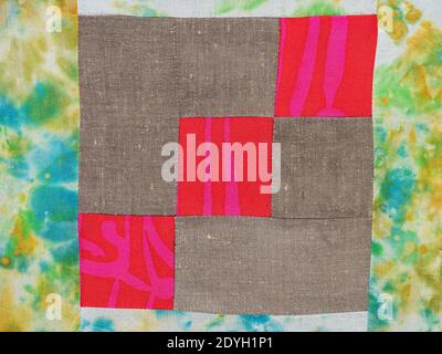textile background - sewn fragment of patchwork cloth from red and brown fabrics Stock Photo