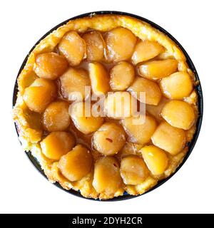 top view of homemade caramelised apple pie Tarte Tatin on plate cut out on white background Stock Photo