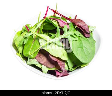 various fresh leaves of leafy vegetables in white bowl cut out on white background Stock Photo