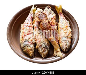 fried red mullet fishes on brown ceramic plate cut out on white background Stock Photo