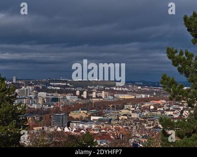 Panoramic view of center and northern part of Stuttgart, capital of Baden-Wuerttemberg, with main station and opera house framed by coniferous trees. Stock Photo