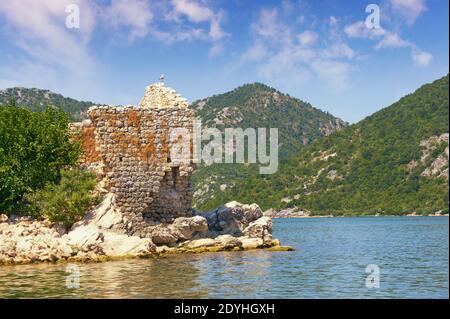 Picturesque lake and ruined fort on small island. View of Lake Skadar - the largest lake in the Balkans. Fortress Grmozur. Montenegro Stock Photo