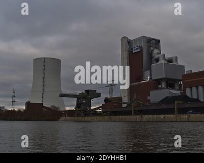 View of coal-fired Heilbronn Power Station operated by Energie Baden-Württemberg (ENBW) with cooling tower, pile of coal and port crane on Neckar. Stock Photo