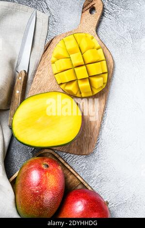 Mango fruit cut into cubes on a cutting Board. Gray background. Top view Stock Photo