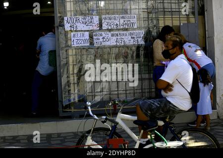 Guacara, Carabobo, Venezuela. 26th Dec, 2020. December 26, 2020, Hernandez, Guacara, Carabobo, People wait to make food purchases at the doors of a store that publishes prices in dollars. The U.S. currency is already a cost reference in Venezuela due to the hyperinflation and constant fluctuation of the value of the dollar. In Guacara, Carabobo state. Photo: Juan Carlos Hernandez. Credit: Juan Carlos Hernandez/ZUMA Wire/Alamy Live News Stock Photo