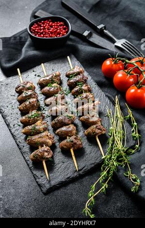 Grilled shish kebab with chicken hearts. Black background. Top view Stock Photo