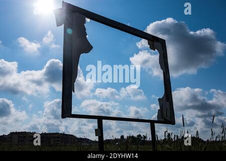Rusty abandoned advertising outdoor frame with blue sky with clouds and shinny sun in the background. Stock Photo