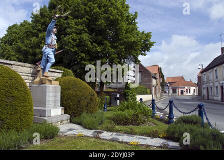 A colorfully painted metal statue of a WW I French soldier stands as a monument in the center of La Commune de Cappy, France. Stock Photo