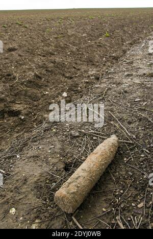 A farmer plowed up a World War 1 artillery shell during spring plowing and laid it on the side of the field for disposal, near Vaux-sur-Somme, Stock Photo