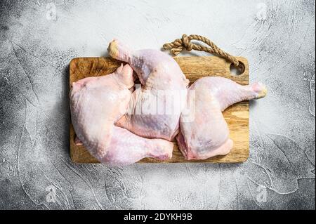 Fresh raw chicken thighs, legs on a chopping Board. Gray background. Top view. Stock Photo