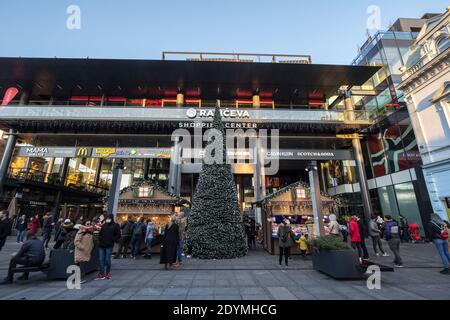 BELGARDE, SERBIA - DECEMBER 6, 2020: giant chrismtas tree in front of a small belgrade christmasmarket on rajiceva mall with people wearing face masks Stock Photo