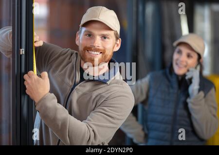 happy young construction worker installing window in house Stock Photo