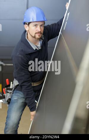 a man builder is holding a door Stock Photo