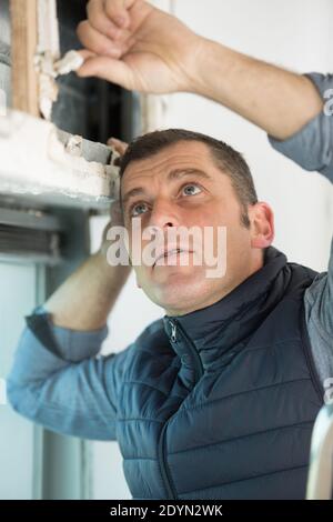 a man drilling window frame Stock Photo