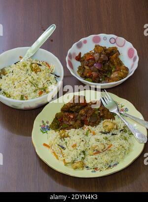 chinese food served on plate. delicious and tempting fried rice and chilli chicken. famous in indian restaurants. close up shot. top view. Stock Photo