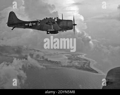 A U.S. Navy Douglas SBD-5 Dauntless dive bomber of Bombing Squadron 5 (VB-5) from the aircraft carrier USS Yorktown (CV-10) over Wake Island, 5 or 6 October 1943 Stock Photo