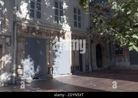 Marseille, France, Early Morning sunlight casts shadows on a closed cafe bar in historic the Le Panier District. Stock Photo