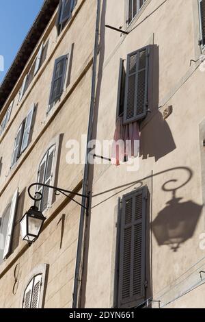 Marseille, France, The late afternoon sun casts a shadow of an old street lamp across a traditional Mediterranean house in Le Panier neighborhood. Stock Photo