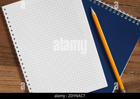 Opened notepad with empty page and pencil on wooden table, top view. Space for your text Stock Photo