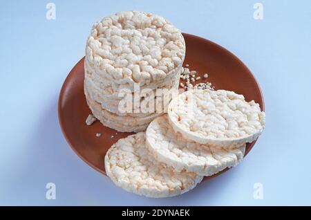 Rice crackers in brown plate on blue background Stock Photo