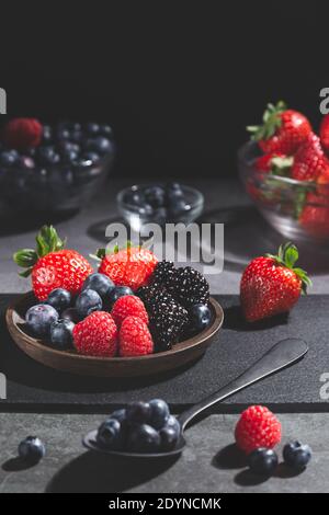 Mixed berries on dark background. Vertical format. Stock Photo