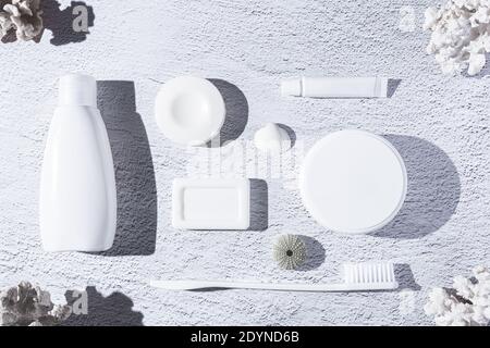Variety of personal hygiene products on white background with corals and seashells.  Top view. Stock Photo