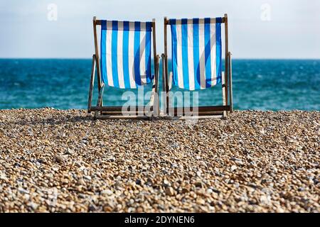 Two empty deck chairs, folding chairs on the beach, Brighton, England, United Kingdom Stock Photo