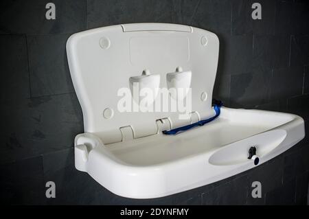 Baby changing station. Dark mineral wall background Stock Photo