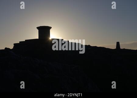 4 - Lens flare as the sun rises round the diamond jubilee toposcope at the top of the malvern hills. Area of natural beauty in worcestershire. Stock Photo