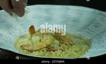 Chef Adds Grated Cheese To Cooked Risotto