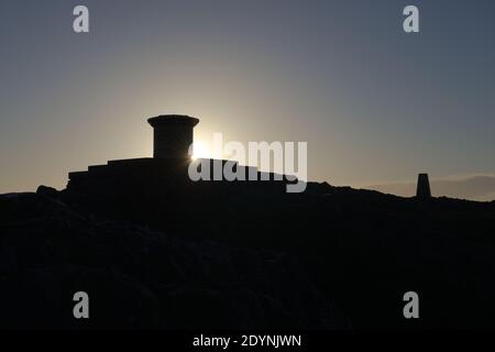 5 - Sunrise silhouette of the diamond jubilee toposcope at the summit of the malvern hills, the worcestershire beacon. Clear sky and sun star flare Stock Photo