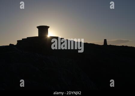 7 - Bright morning sun flares round the stone toposcope at the top of the malvern hills, aka worcestershire beacon. Iconic horizontal silhouette Stock Photo