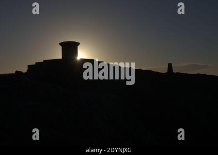 8 - Dark early morning sunrise behind the summit of the worcestershire beacon. Featuring the toposcope and trig point as it is the highest point. Stock Photo