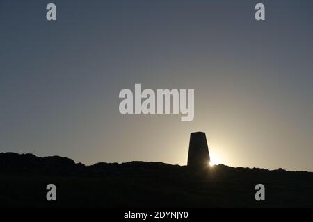 9 - Trig point aka triangulation station at the hilltop summit of the worcestershire beacon near malvern town. Concrete pillar silhouetted at sunrise Stock Photo