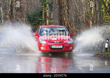 Hastings, East Sussex, UK. 27 Dec, 2020. UK Weather: The B2089 near Hastings is flooded with rain water making it difficult for drivers to pass. A learner driver makes his way through making a huge splash. Photo Credit: Paul Lawrenson/Alamy Live News Stock Photo