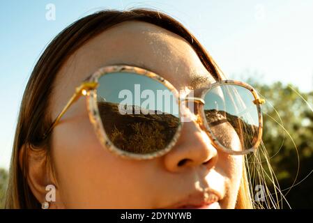 Closeup of girl looking at The Hollywood Sign, reflected in sunglasses. Los Angeles, California, US. Aug 2019 Stock Photo