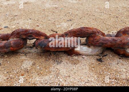 Old rusty chain on the beach sand Stock Photo